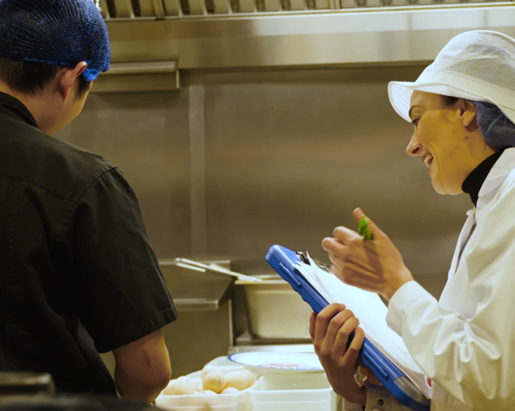 kitchen staff sharing the officer their food safety culture